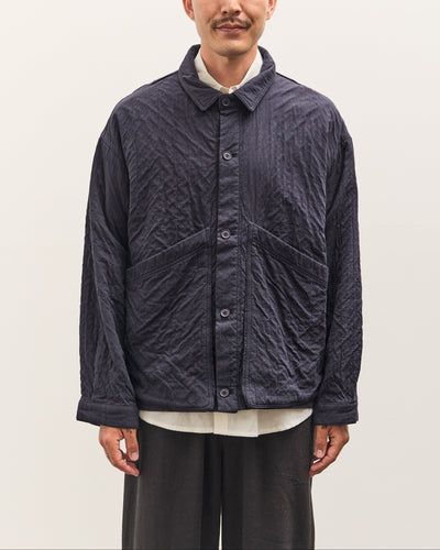 Man wearing a dark quilted jacket on a plain background