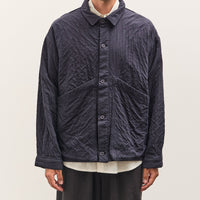 Man wearing a dark quilted jacket on a plain background