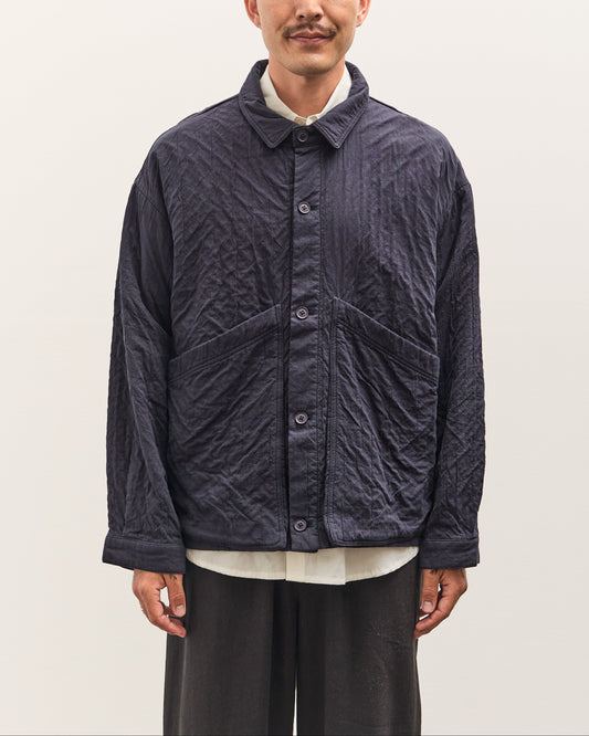 Man wearing a dark quilted jacket on a plain background