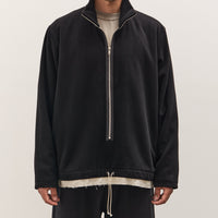 Person wearing a black half-zip sweatshirt on a plain background