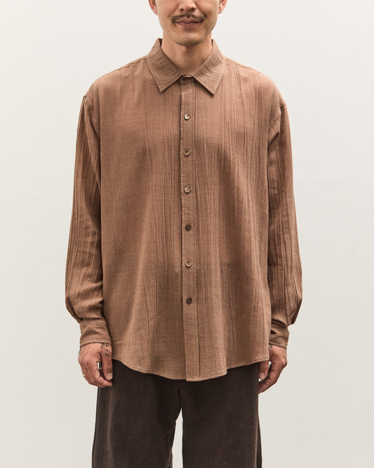 Man wearing a brown shirt against a plain background