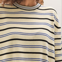Person wearing a striped sweater with black and blue horizontal lines on a white background