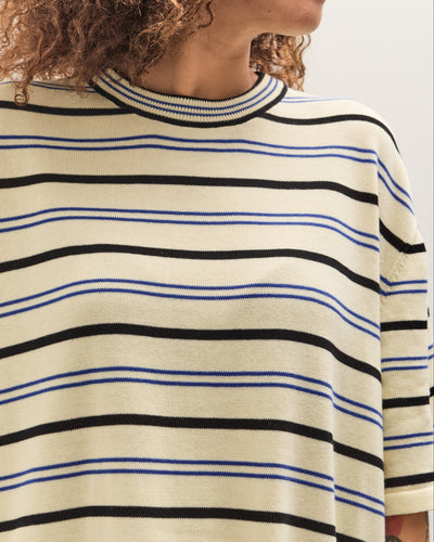 Person wearing a striped sweater with black and blue horizontal lines on a white background
