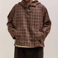 Person wearing a brown plaid hoodie against a plain background