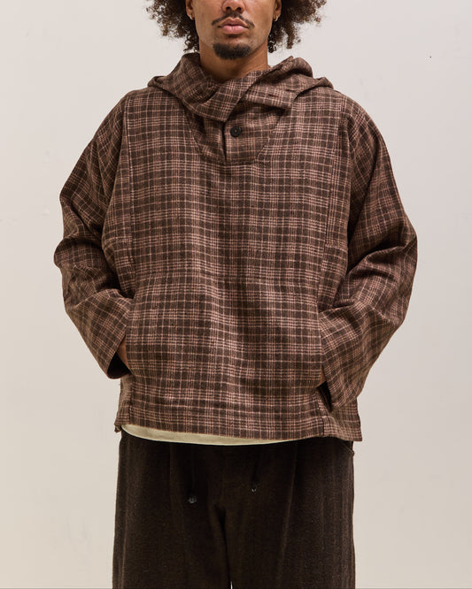 Person wearing a brown plaid hoodie against a plain background