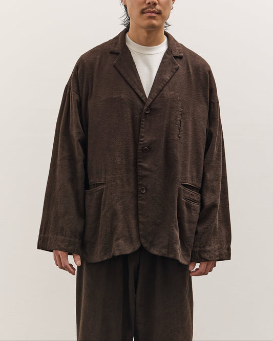 Man wearing a brown jacket and pants on a white background