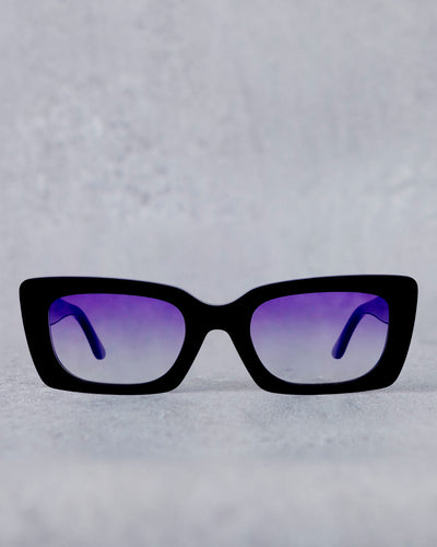 Black sunglasses with purple lenses on a light gray background